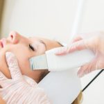 Woman getting ultrasound skin cleaning at beauty salon